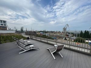 een terras met 2 stoelen en een tafel op een balkon bij Żurawie II Popiełuszki 2A 51 in Gdańsk