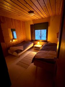 una camera da letto con due letti e una finestra di Villa Lakeside a Utsjoki