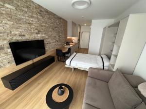 een slaapkamer met een bank en een bakstenen muur bij Żurawie II Popiełuszki 2A 51 in Gdańsk