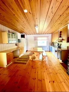 una grande cucina con pavimenti in legno e un grande soffitto in legno di Villa Lakeside a Utsjoki
