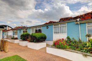 a blue house with plants in front of it at 92 Blueberry Lodge - Sea Views in Westward Ho