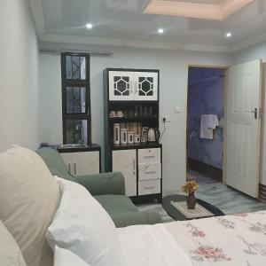 a living room with a bed and a couch and a room with at Carlcyn 263 Cottage in Bulawayo