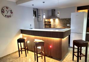 a kitchen with a bar with stools and a refrigerator at La Friandise in Seppois-le-Bas