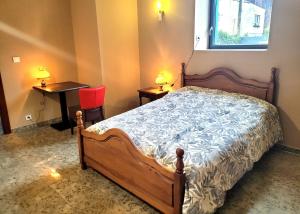 a bedroom with a bed and a table and a chair at La Friandise in Seppois-le-Bas