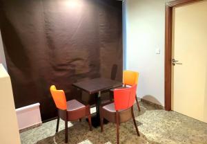 a table with four chairs and a black wall at La Friandise in Seppois-le-Bas +1 photo