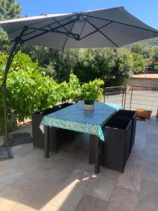 a table with an umbrella on a patio at Chez Suzanne in Corbara