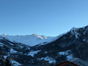 a snow covered mountain range with a house in the foreground at Chalet Oslo by Lodji in Saint-Marcel +33 photos