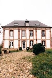 ein großes Backsteinhaus mit einem Hof davor in der Unterkunft Maison Le Catelier in Le Catelier