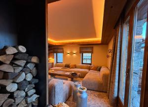 a living room with a couch and a pile of logs at Chalet Oslo by Lodji in Saint-Marcel