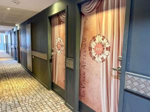 un corridoio con porte e tende in un corridoio di ibis Styles Nimes Gare Centre a Nîmes