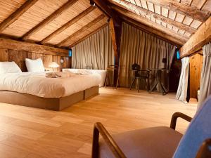a bedroom with a bed and a chair in a room at Chalet Oslo by Lodji in Saint-Marcel