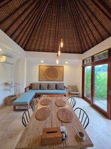 een eetkamer met een tafel en een bank bij Guava Garden in Gili Trawangan