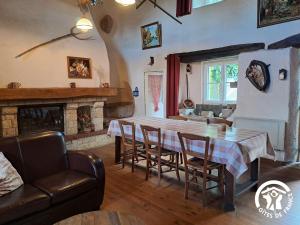 a dining room with a table and chairs and a fireplace at Calouze in Gijounet