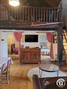 a living room with a tv and a couch and a table at Calouze in Gijounet