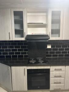 a kitchen with a stove and a black counter top at 85 Hidden Gem in Newlands