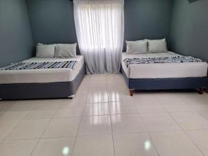 twee bedden naast elkaar in een kamer bij Windy Hill Suites in Bacolet