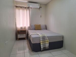 een kleine slaapkamer met een bed en een raam bij Windy Hill Suites in Bacolet