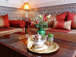 ein Wohnzimmer mit einem Tisch und einer Blumenvase in der Unterkunft Riad Viva in Marrakesch