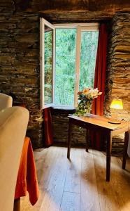 een kamer met een tafel met bloemen en een raam bij Le moulin de cameliere in Caudebronde