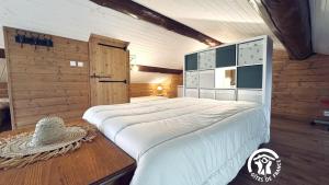 een slaapkamer met een groot wit bed in een kamer bij Le moulin de cameliere in Caudebronde