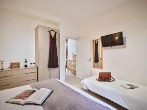 a bedroom with two beds and a tv on a wall at Domus Pallium in Siena