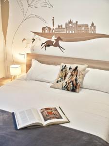 a bedroom with a bed with a book on it at Domus Pallium in Siena +18 photos