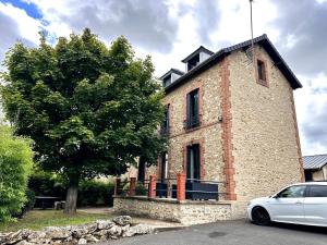 a white car parked in front of a brick building at Appartement - Le Prestige in Saint-Chéron