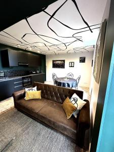 a living room with a brown couch and a table at Appartement - Le Prestige in Saint-Chéron +3 photos