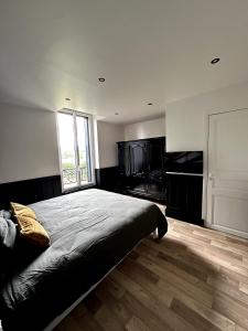 a bedroom with a large bed with a large window at Appartement - Le Prestige in Saint-Chéron