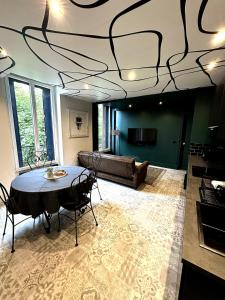 a living room with a table and a couch at Appartement - Le Prestige in Saint-Chéron