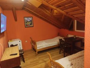 a bedroom with a bed and a desk and a table at Motel Lovac in Štrpce