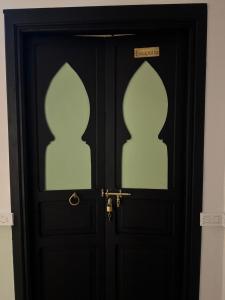 a black door with two windows on it at Riad Douha in Marrakech