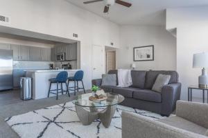 een woonkamer met een bank en een tafel bij Landing Apartments - Redbud Ranch in Broken Arrow