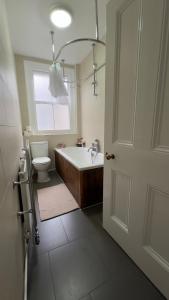 un bagno con vasca, WC e lavandino di Sweet cozy room in Fulham a Londra