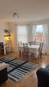 un soggiorno con tavolo, sedie e una finestra di Sweet cozy room in Fulham a Londra