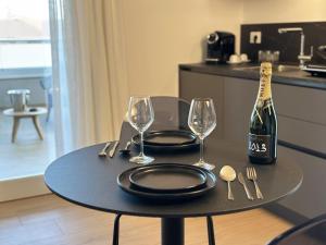 a table with a bottle of champagne and two glasses at Mediterranea Apartments Sunrise in Assemini