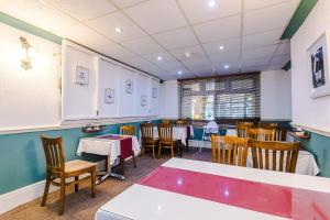 een eetkamer met witte tafels en stoelen bij Blackpool Lodge in Blackpool