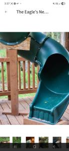 a green play structure on a wooden deck at The Salmon Suite in Palmer