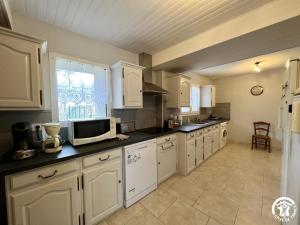 a kitchen with white cabinets and a microwave at Peyret in Cépie