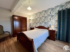 a bedroom with a bed with a blue and white wallpaper at Peyret in Cépie