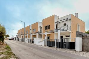 Une rangée de maisons sur le côté d'une route dans l'établissement Bright & Airy 3BR Spacious Villa, à Sesimbra