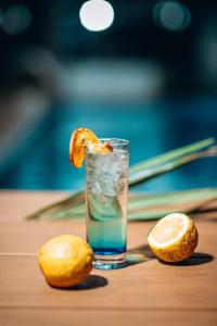 een glas water met een sinaasappelschijfje op een tafel bij Hotel Lubumbashi in Lubumbashi