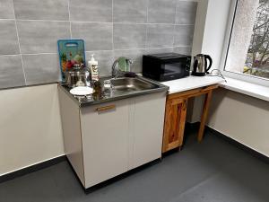 a kitchen with a sink and a microwave at ЛофтХостел in Novoyavorivsk