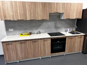 een keuken met houten kasten en een kookplaat met oven bij ЛофтХостел in Novoyavorivsk +38 foto's