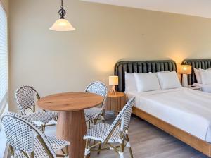 a bedroom with a bed and a table and chairs at Ocean Lodge in Boca Raton