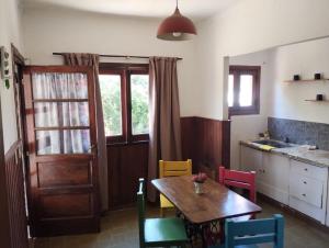 een keuken met een houten tafel en kleurrijke stoelen bij Casa de playa. Quequen in Quequén