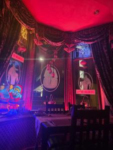 a room with red lights and curtains and a table at Westholme Hotel in Blackpool