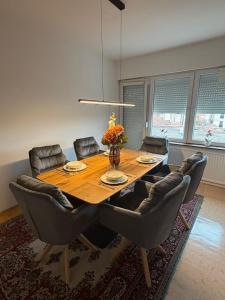 een eetkamer met een tafel en lederen stoelen bij Guest House Kragujevac in Kragujevac