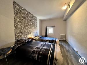 2 Betten in einem Zimmer mit einer Wand in der Unterkunft Chez madou in Roquefort-des-Corbières
