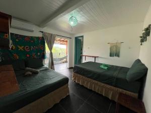 a bedroom with two beds in a room with a window at Vila Pepouze Hostel in Morro de São Paulo